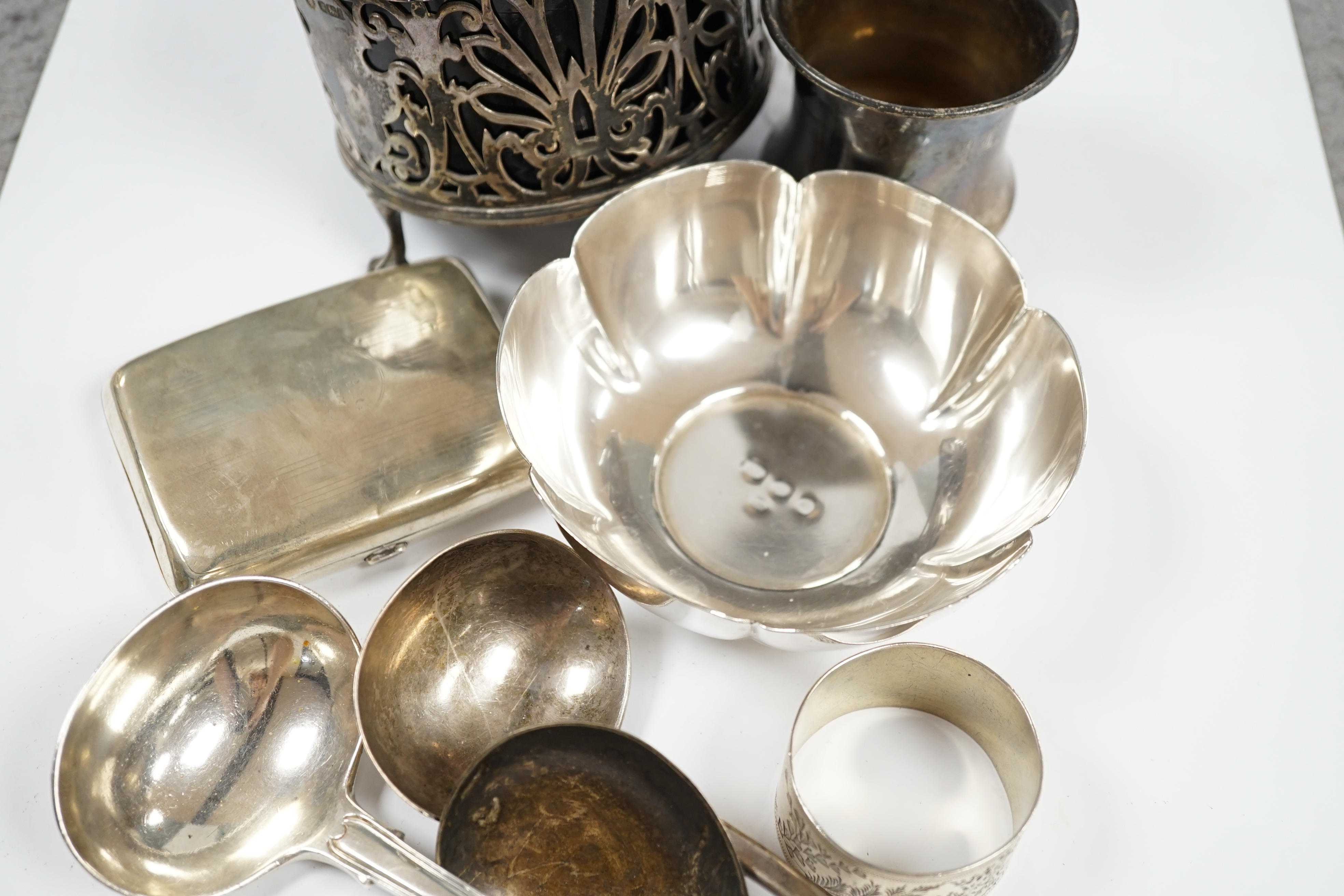 Sundry small silver including a modern bowl by G.J. Dennis, a napkin ring, cigarette case, christening mug and damaged bottle coaster with blue glass liner, together with three items of flatware including a Victorian Iri